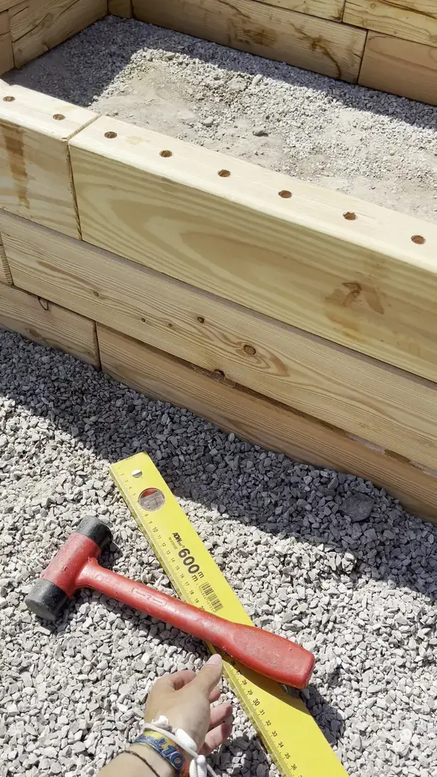 Assembling a wooden raised bed layer by layer