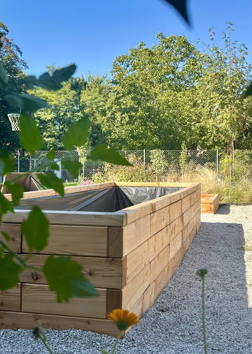 New Brick Premium raised bed with a liner on gravel, ready for soil